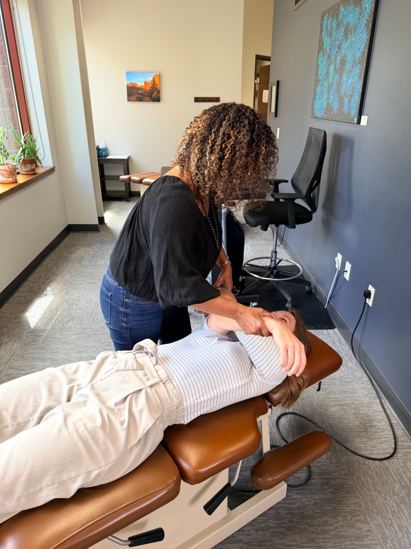Provider guiding a patient's arm through an assisted shoulder mobility exercise