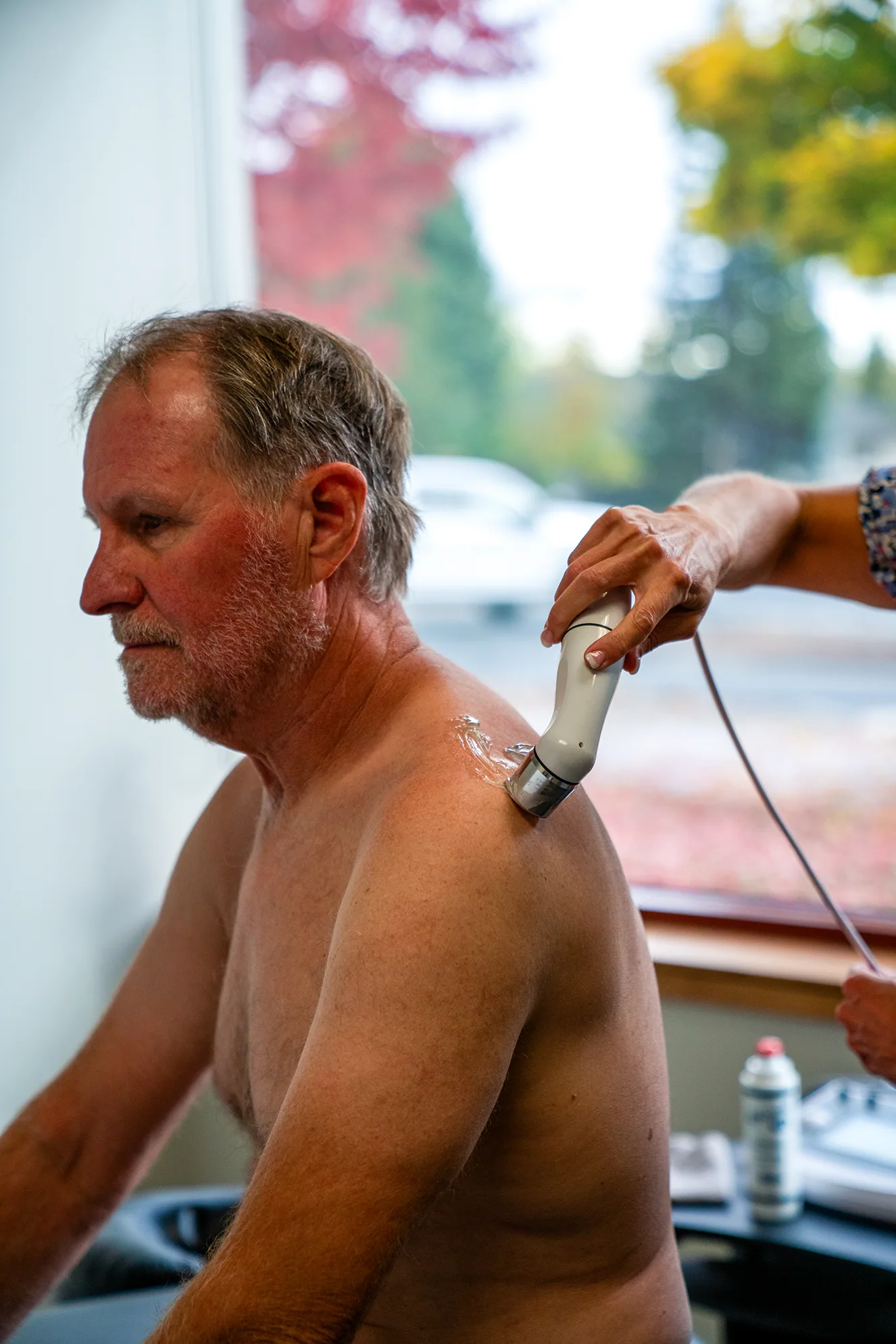 Therapeutic ultrasound applied to a patient's shoulder and upper arm